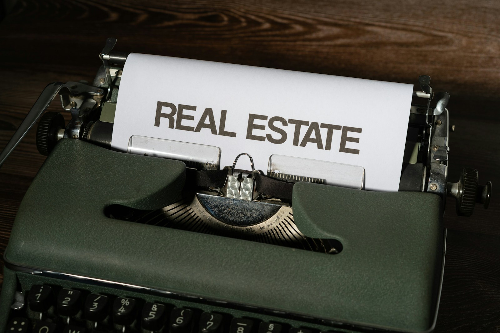 a close up of a typewriter with a real estate paper on it