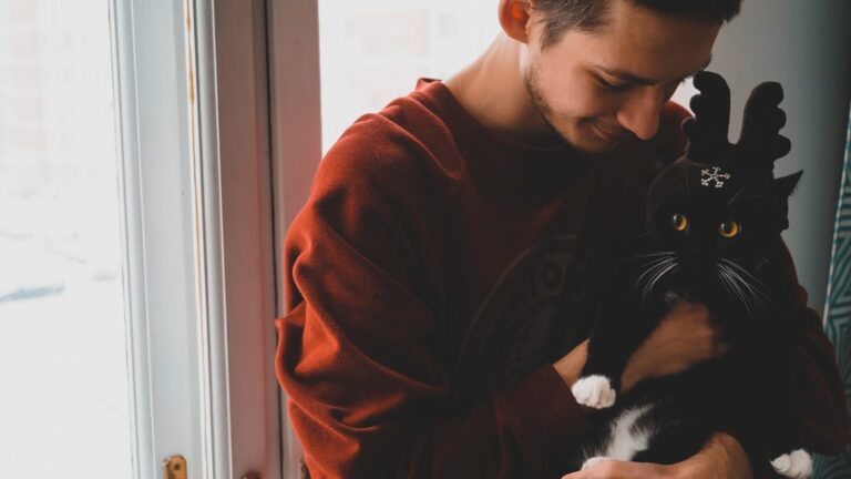 man holding cat near door