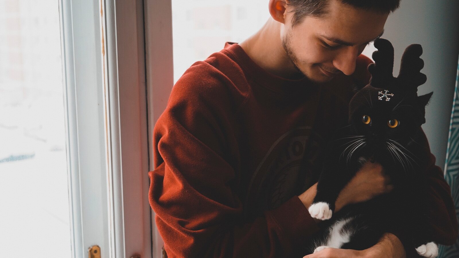 man holding cat near door